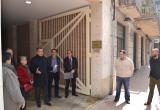 Imatge de la visita de l'alcalde i els veïns al portal del carrer Nou