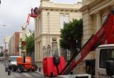 Imatge dels treballs d'instal·lació de la nova il·luminació ornamental a la façana de l'Escola Pompeu Fabra