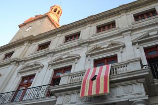 Foto de la senyera amb crespó negre a la façana de l'ajuntament