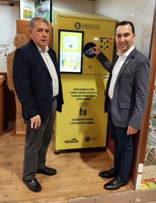 Els regidors Prats i Rubio amb la nova màquina Reciclos al Mercat del Carrilet