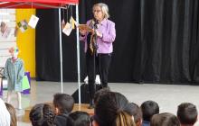 Imatge de la regidora d'Ensenyament i Política Lingüística recitant un poema a l'Escola Rubió i Ors