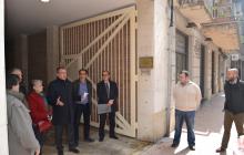 Imatge de la visita de l'alcalde i els veïns al portal del carrer Nou